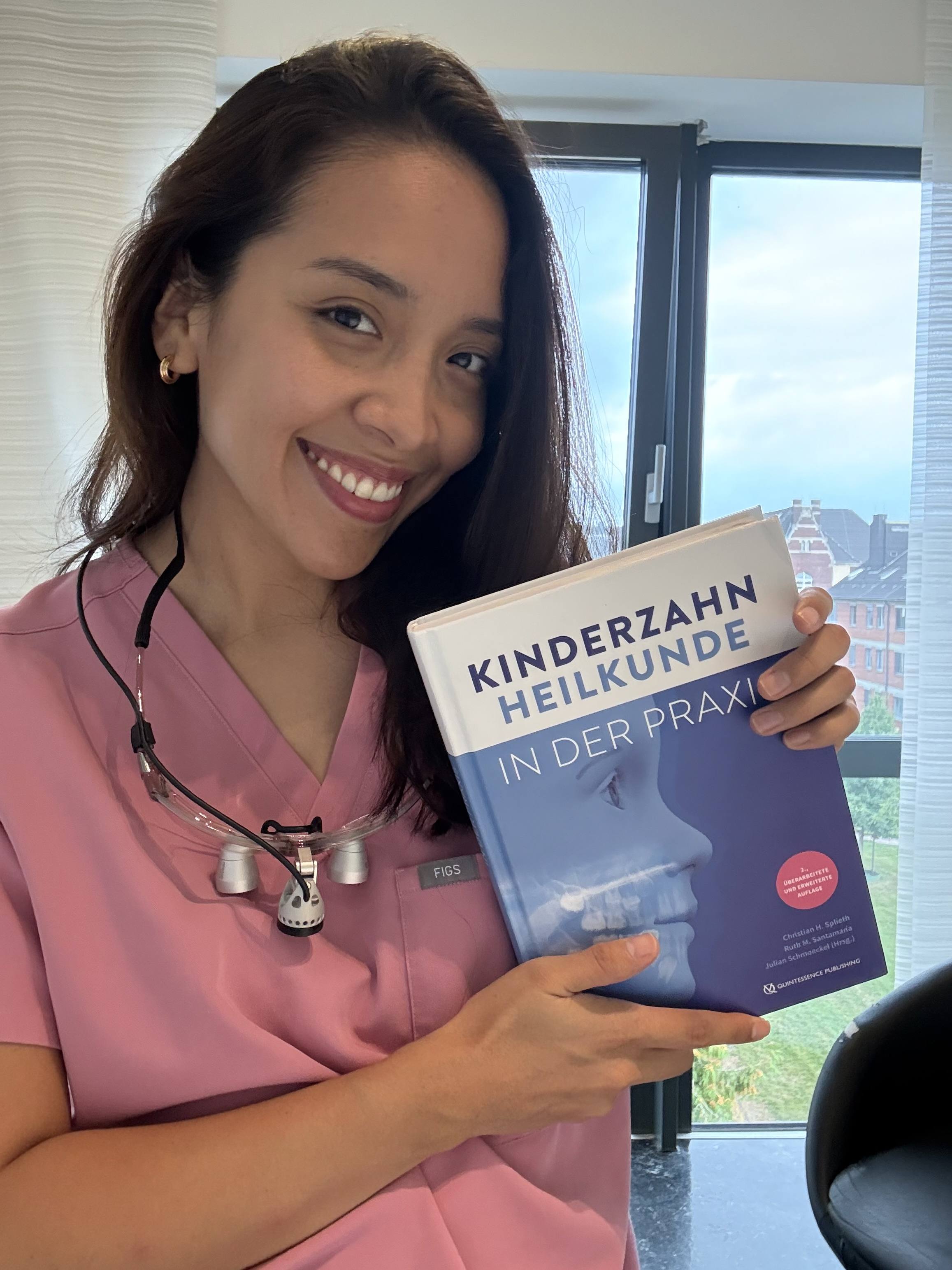 Sheryl Mondorf con un libro de odontología alemán